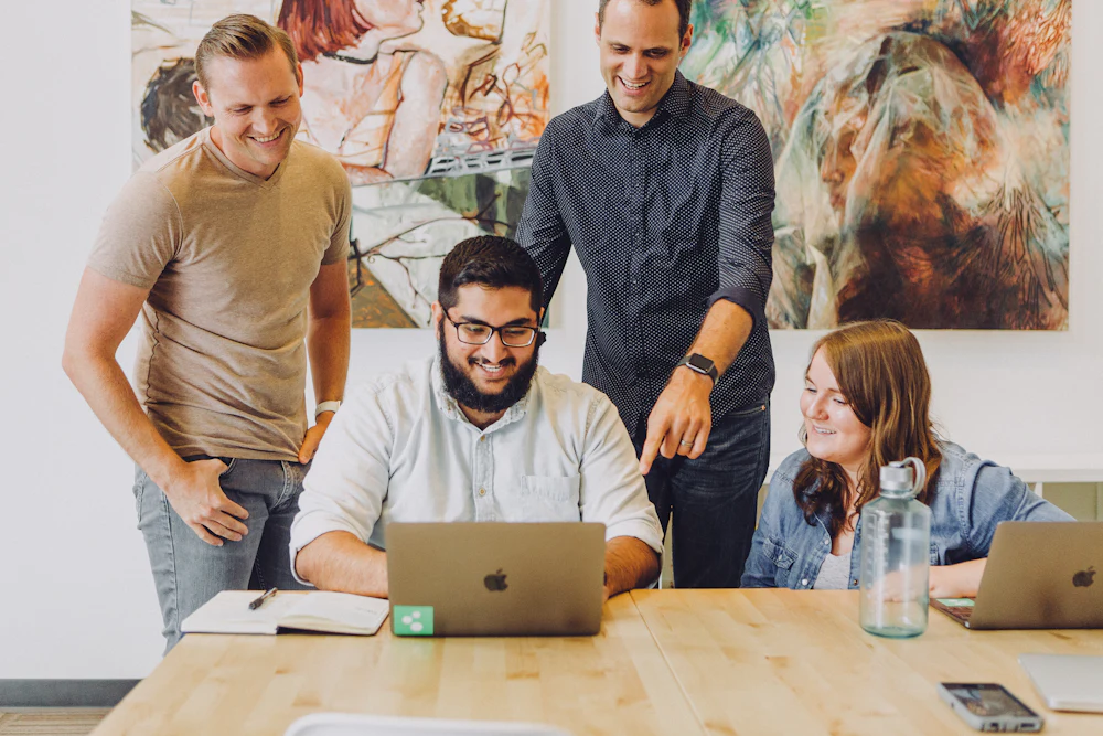 Agency team planning a website project around a laptop