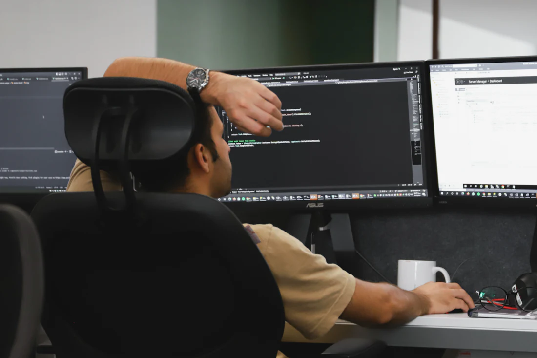 Developer coding a web application on a dark desk setup