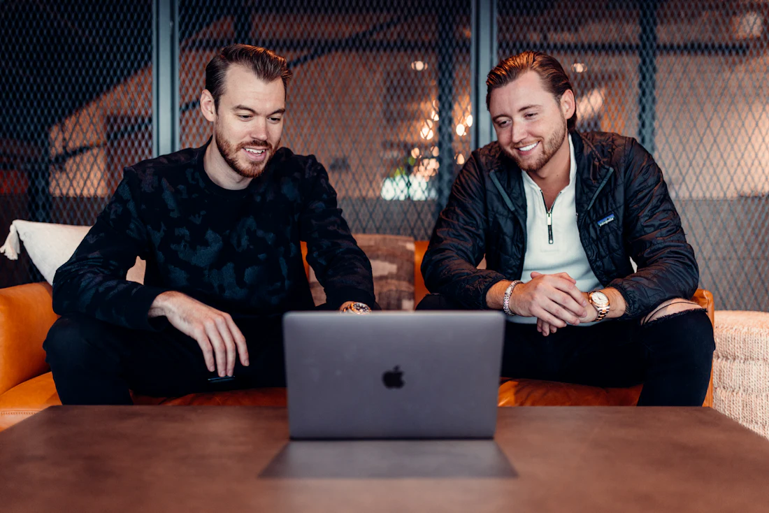 Two developers discussing a project on a laptop