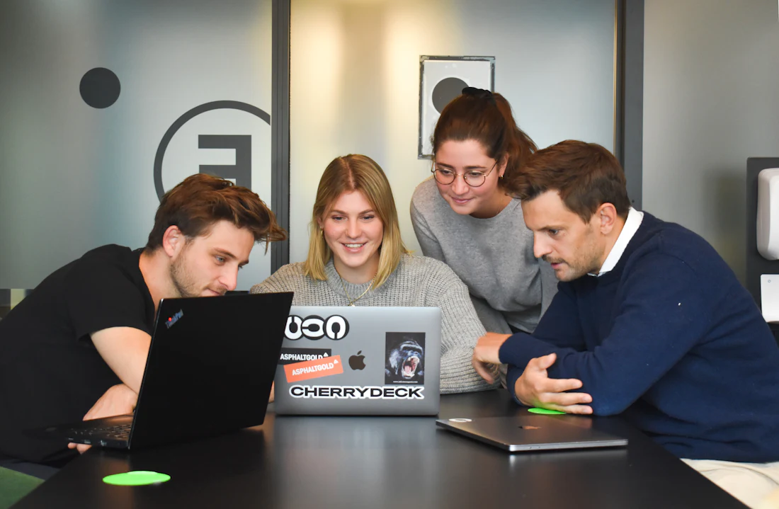 Team collaborating around a laptop