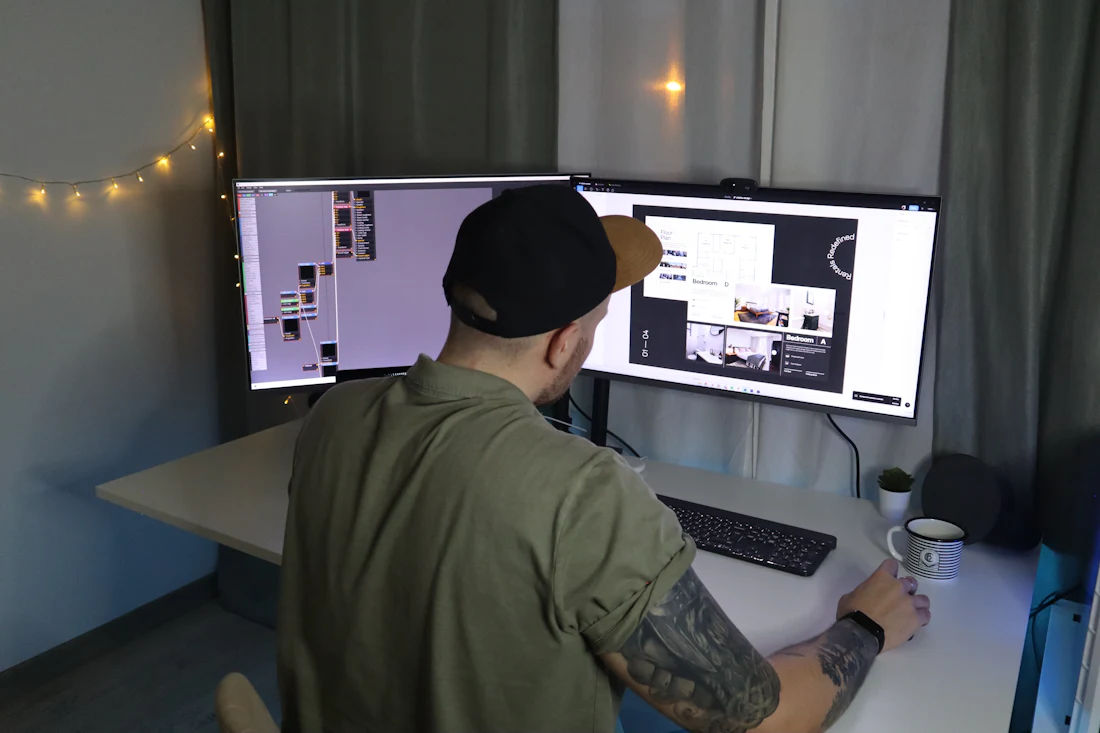 Web designer working on a website layout across two monitors